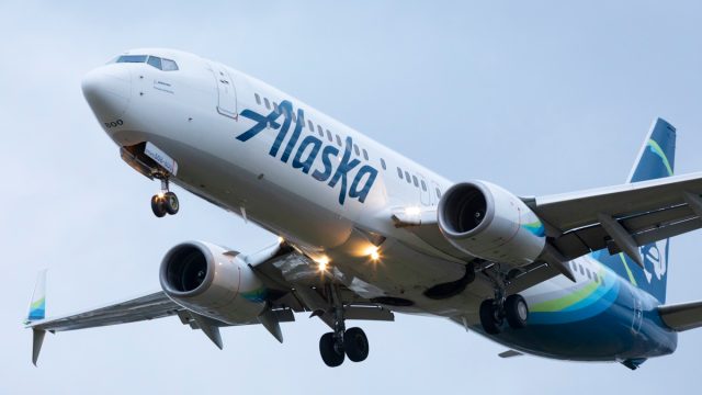 An Alaska Airlines Boeing 737 landing at Portland International Airport at dusk.