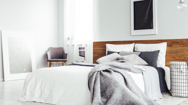 bedroom with white walls and gray blankets on bed