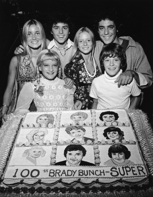 The "Brady Bunch" cast posing with a cake celebrating the show's 100th episode circa 1973