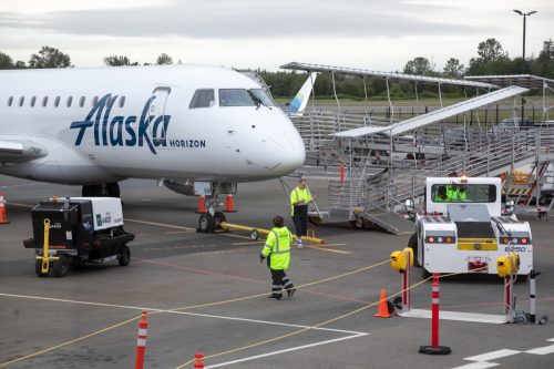 Ground crew working on an Alaska Airlines airplane on the tarmac at the new Paine Field Airport north of Seattle