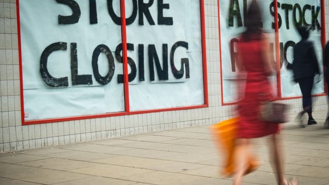 store closing sign with shopper walking past