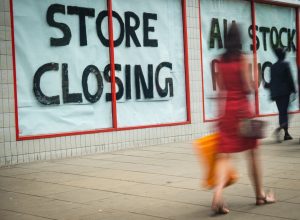 store closing sign with shopper walking past