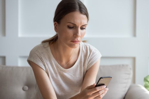 woman looking concerned at her phone
