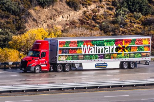รถบรรทุก walmart ที่มีผักและผลไม้อยู่ข้างขับไปตามทางหลวง