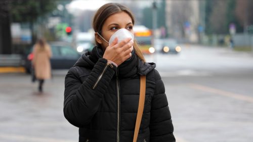 Ein Mädchen, das eine schützende Gesichtsmaske von COVID-19 trägt