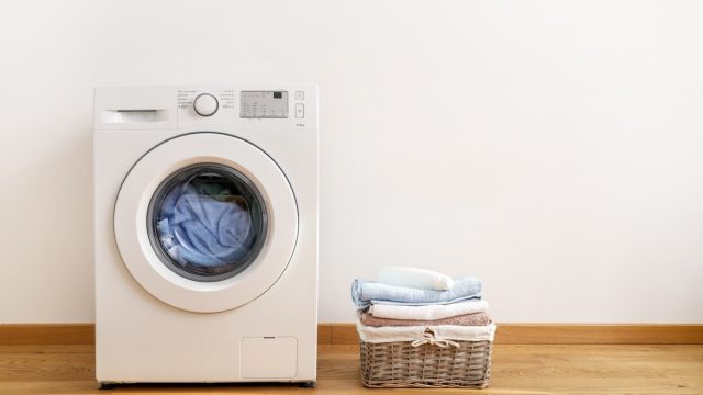 washing machine with laundry basket next to it