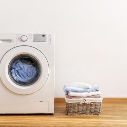 washing machine with laundry basket next to it