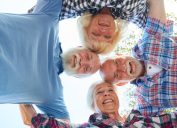 four senior citizens arm in arm