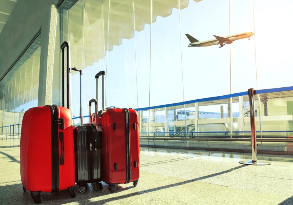 traveling luggage in airport terminal with plane in background