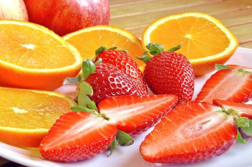 Ein Teller mit Orangen- und Erdbeerscheiben