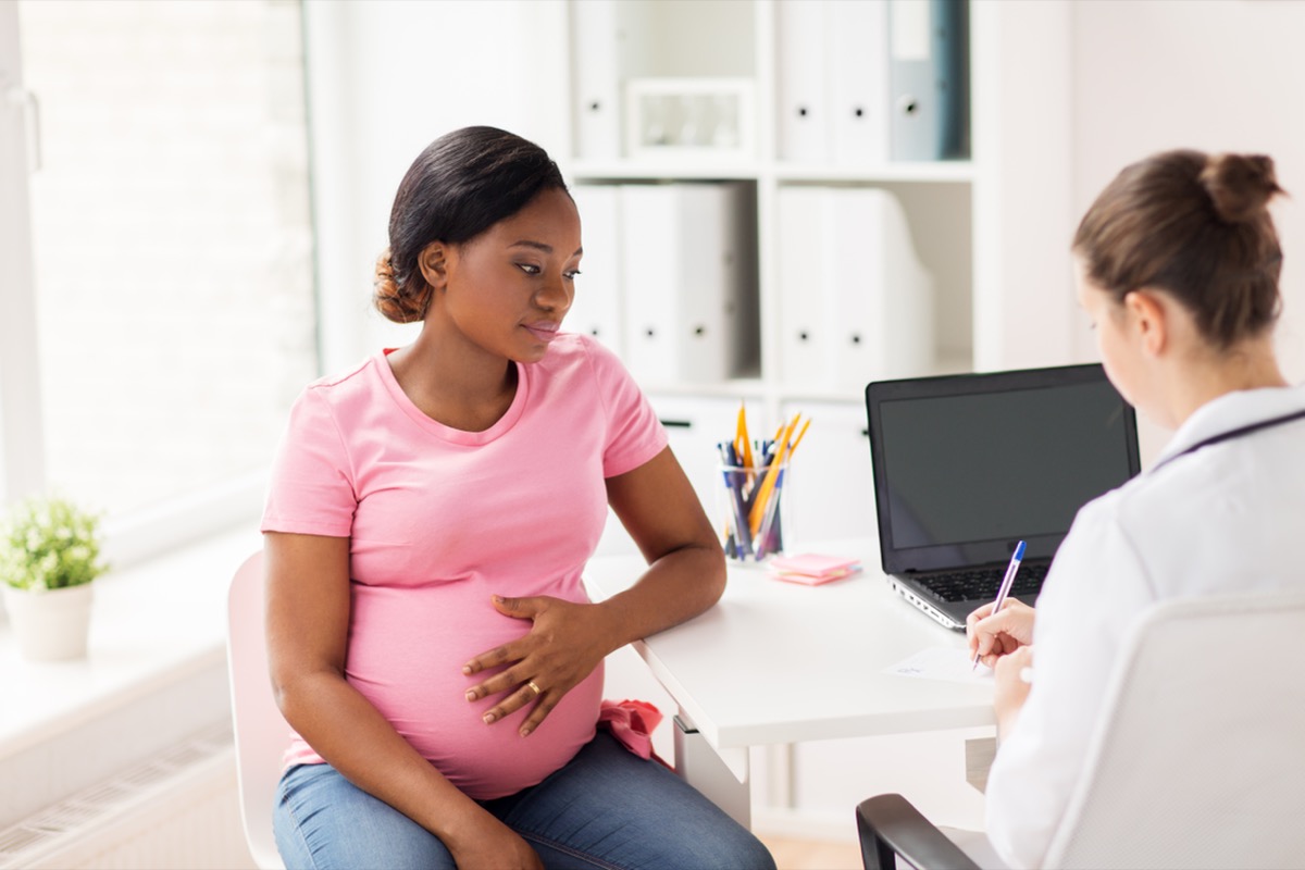 pregnant woman sitting and consulting doctor