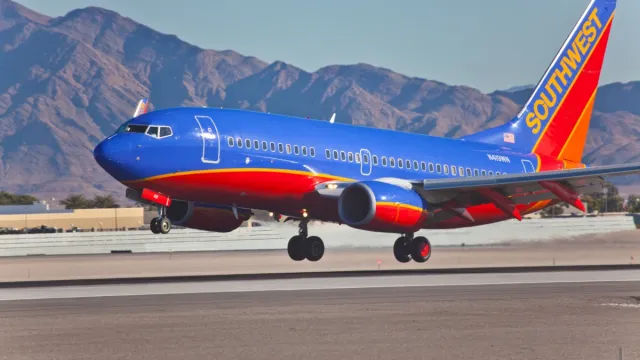 southwest airplane taking off with mountains in the background