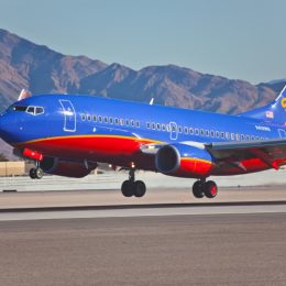 southwest airplane taking off with mountains in the background