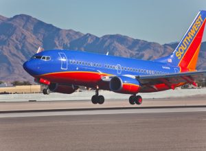 southwest airplane taking off with mountains in the background