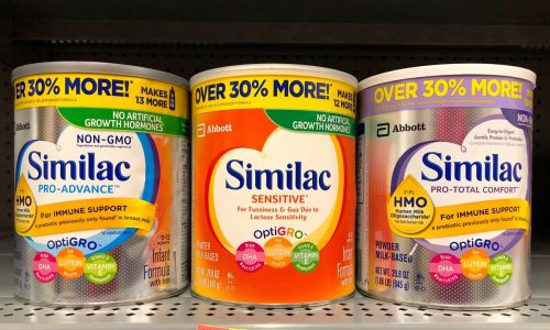 Grocery store shelf with containers of Similac brand powdered formula. Infant formula, is a manufactured food designed and marketed for feeding babies under 1 yr old.