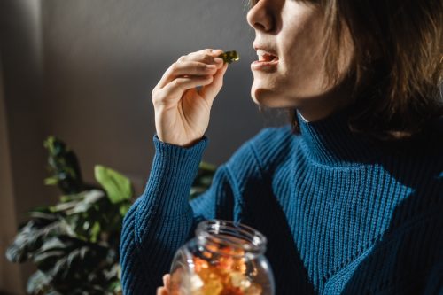 Цбд гума од канабиса - жена једе јестиво лишће слатких слаткиша од корова за алтернативни третман анксиозности - медицинска марихуана