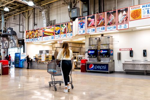 People customers woman walking to exit in Costco discount membership club store during Coronavirus Covid-19 outbreak with empty food court