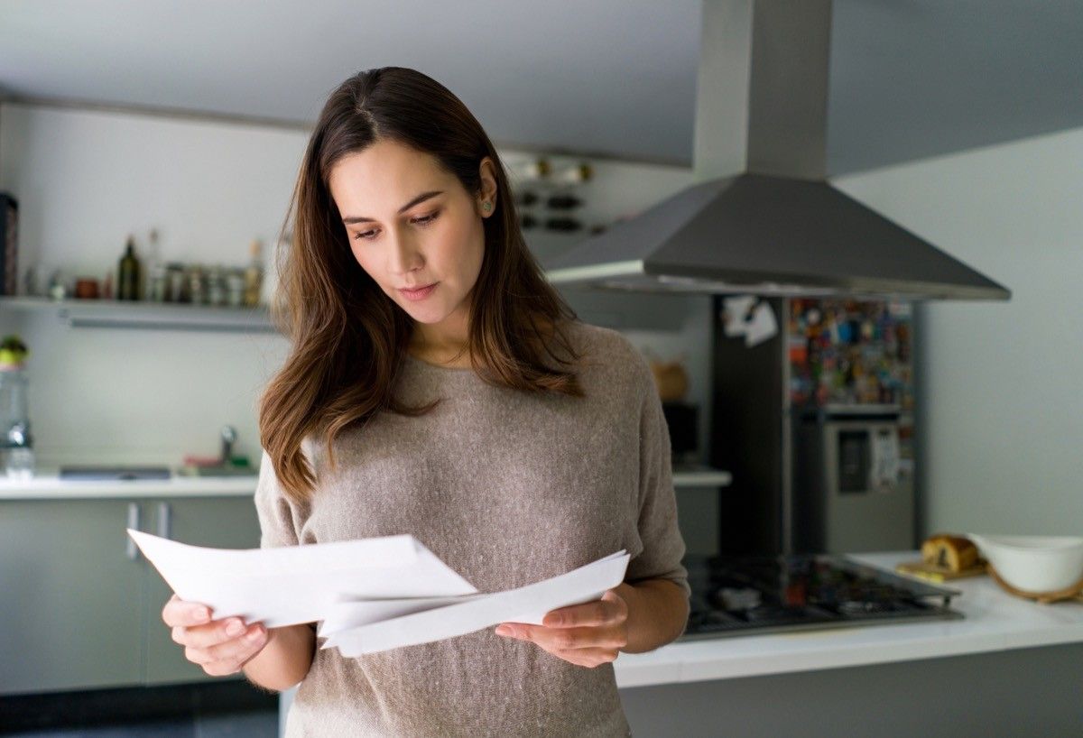 woman at home checking her mail - domestic life concepts