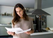 woman at home checking her mail - domestic life concepts