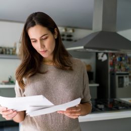 woman at home checking her mail - domestic life concepts