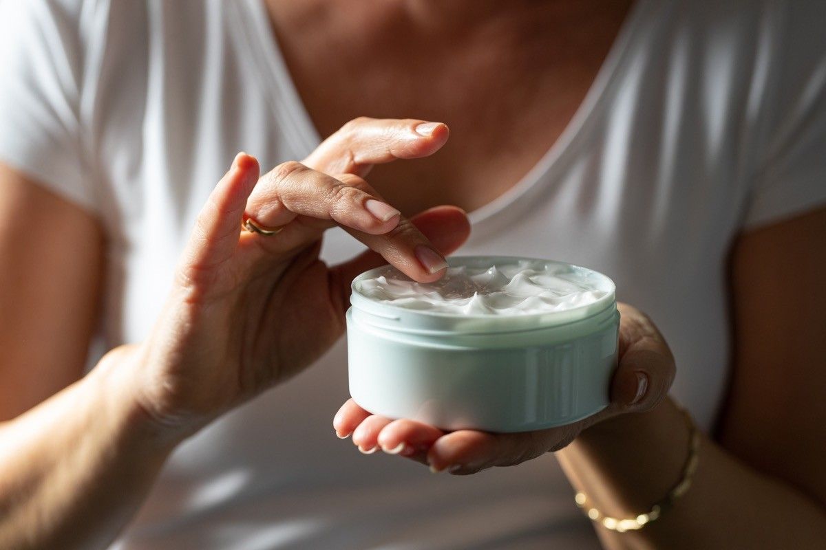 woman putting cream on