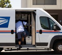A USPS Postal worker delivers mail.