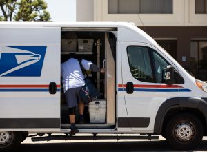 A USPS Postal worker delivers mail.