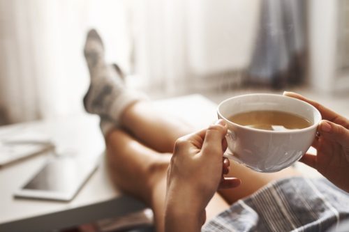 woman lounging and drinking a cup of tea