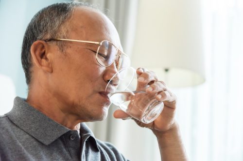 Велики човек пије воду из шоље