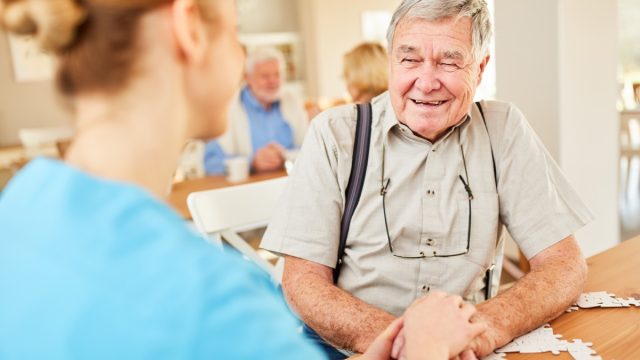 senior man with dementia smiling at caregiver