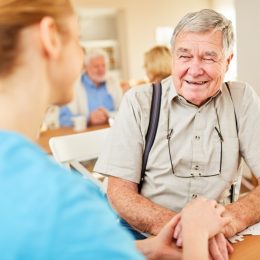 senior man with dementia smiling at caregiver