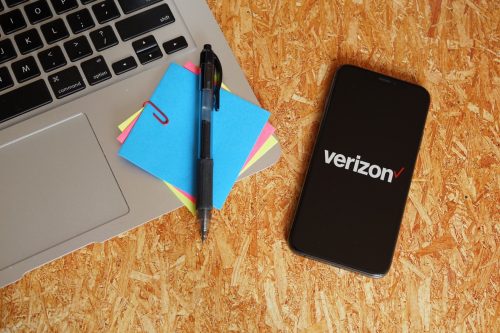 verizon logo on phone next to laptop with post-its