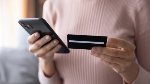 woman holding cellphone and credit card