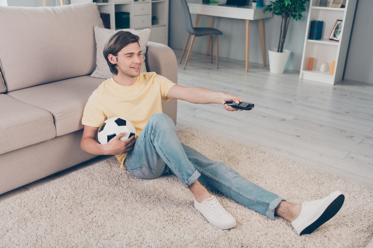 Man Holding Soccer Ball and Remote Control