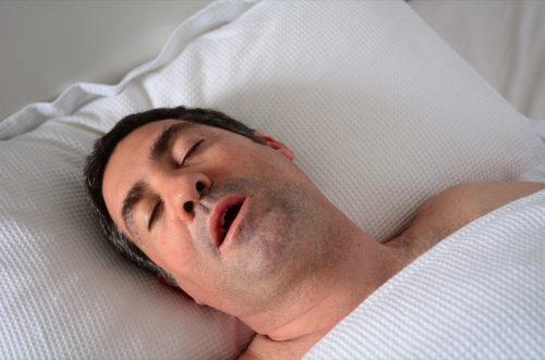 middle-aged man snoring in bed