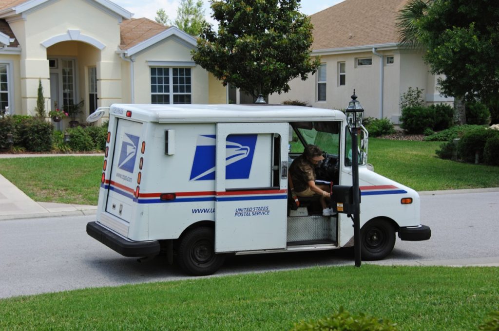 USPS mail carrier delivering mail
