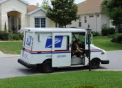USPS mail carrier delivering mail