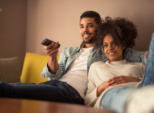 man and woman watching TV