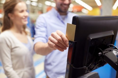 couple swiping credit card at self-checkout