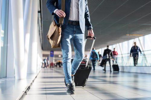 Mann mit Gepäck zu Fuß durch den Flughafen