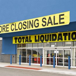 A storefront covered in going out of business signs