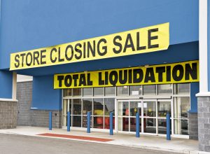 A storefront covered in going out of business signs