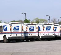 United States Postal Service mail delivery vehicles await deployment in Franklin Park, Illinois.