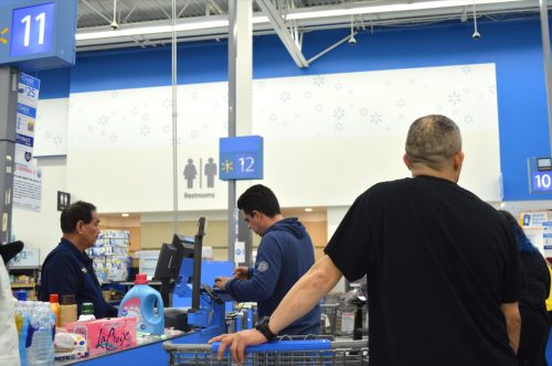 Walmart este cel mai mare lanț de retail de consumatori din țară.  Consumatorii stau la coada pentru a-si plati cumparaturile.