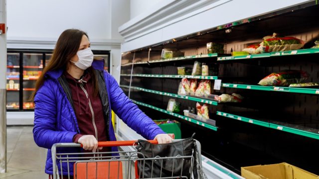 Woman with protection face mask and gloves shopping at supermarket. Coronavirus concept.