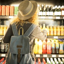 A woman shopping from a beverage display case in an airport store