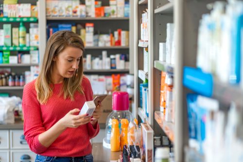 A woman shopping for supplements or medication in a store