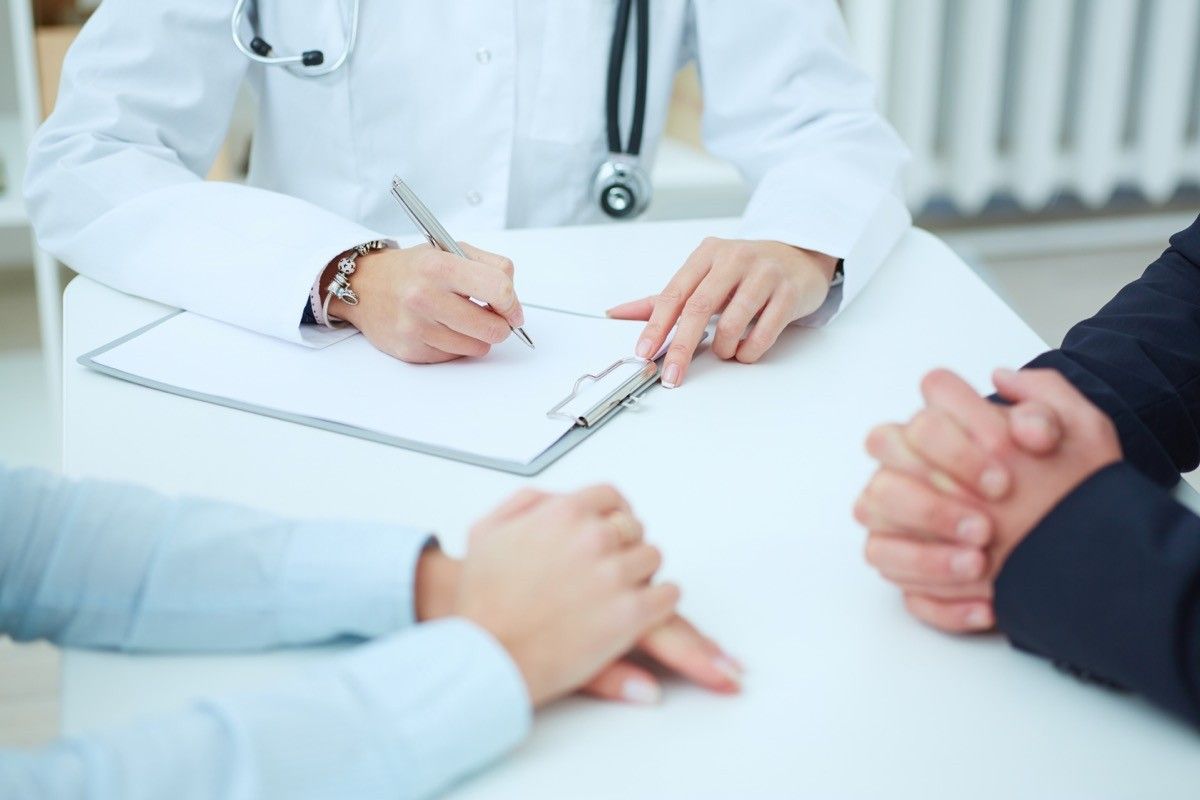 Couple talking to doctor closeup hands