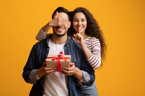 woman surprising boyfriend with presents on his birthday