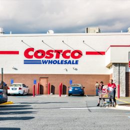 People with shopping carts filled with groceries goods, products walking out of Costco store in Virginia in parking car lot